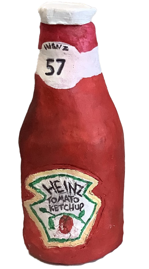 A handcrafted clay bottle modeled after a Heinz tomato ketchup container, featuring vibrant red paint and a detailed label.