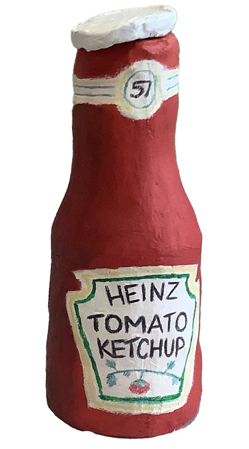 A clay sculpture resembling a Heinz tomato ketchup bottle, painted red with a white cap and detailed label.