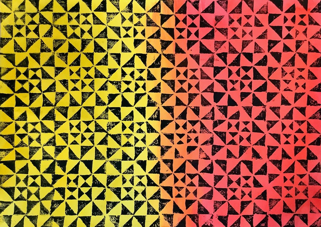 A printmaking project featuring a vibrant pattern of yellow and orange triangles on a black background, showcasing a geometric design.