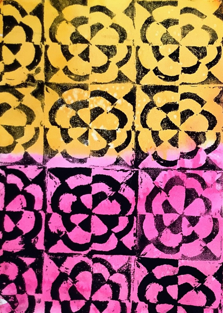 A printmaking project featuring a colorful pattern design, with yellow and pink flowers arranged in a grid format, showcasing contrasting colors and shapes.