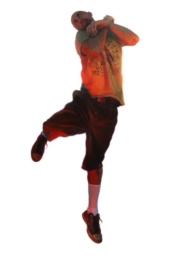 A person in mid-dance, wearing a colorful t-shirt and shorts, with one leg raised and arms crossed near the neck, captured against a white background.